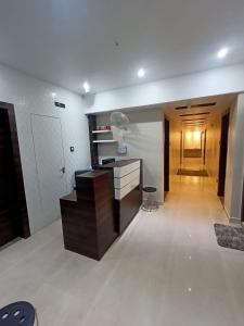 a room with a kitchen with a desk and a hallway at Aditya Inn in Guwahati