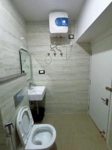 a bathroom with a toilet and a sink at Aditya Inn in Guwahati