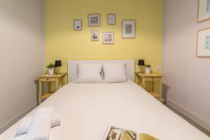 a bedroom with a large white bed with two tables at Apartments WS Mouffetard - Panthéon in Paris
