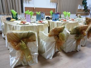 un grupo de mesas con sillas blancas con ropa y comida en Pensiunea Confort, en Buşteni