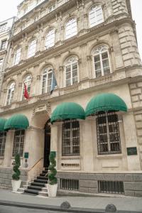 The Bank Hotel Istanbul, a Member of Design Hotels في إسطنبول: مبنى أمامه مظلات خضراء