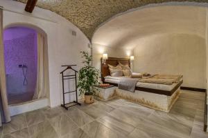 1 dormitorio con cama y pared púrpura en Barlang Noszvaj, en Noszvaj