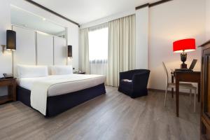 Habitación de hotel con cama, escritorio y silla en Meliá Milano en Milán