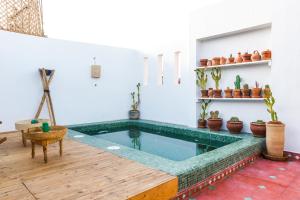 una piscina in una stanza con tavolo e piante in vaso di Riad Dada Mouss & Suites a Marrakech