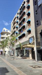 ein Hotelgebäude mit einer Uhr auf der Vorderseite in der Unterkunft Hotel Atlántico Centro in Santa Cruz de Tenerife