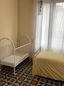 a bedroom with two cribs and a window at Le Rameau in Sainte-Menehould