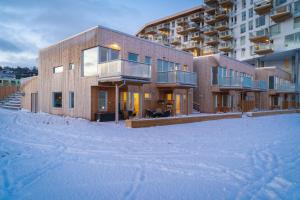 a building in the snow in front of a building at SKIR 2 Bdr CORNER VIEW APARTEMENT in Tromsø
