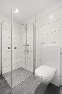 a white bathroom with a toilet and a shower at SKIR 2 Bdr CORNER VIEW APARTEMENT in Tromsø