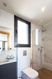 
a white toilet sitting next to a bath tub in a bathroom at Apartamentos Playa De Los Barcos in Isla
