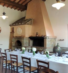 a dining room with a table and a fireplace at Agriturismo Tenuta Cantagallo in Montelupo Fiorentino