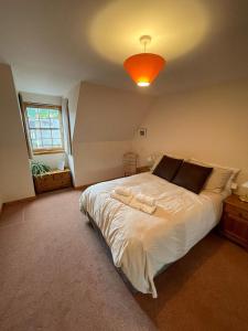 a bedroom with a large white bed with a light at Lovely and Spacious 2BD Holiday Retreat Ballater in Ballater
