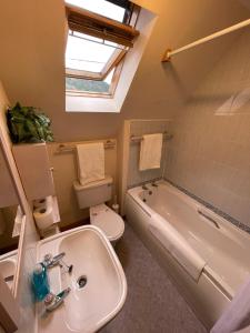 a bathroom with a sink and a toilet and a tub at Lovely and Spacious 2BD Holiday Retreat Ballater in Ballater