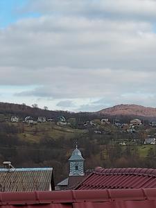a view of a town with a clock tower at Hartiesti county Arges in Câmpulung