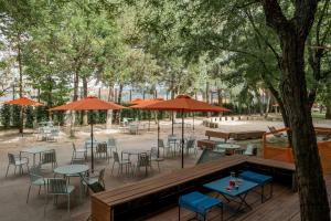 un patio al aire libre con mesas, sillas y sombrillas en Combo Bologna en Bolonia