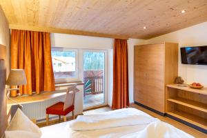 a hotel room with a bed and a window at Hotel Tiroler Herz in Hinterhornbach