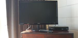 uma televisão de ecrã plano em cima de uma cómoda em Roadside Motel em Waiouru