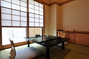 a room with a table and a large window at Yumoto Itaya in Nikko