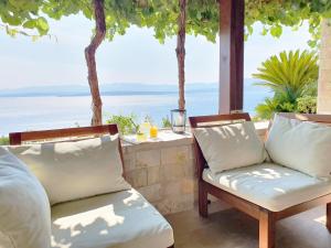 a patio with two chairs and a view of the ocean at Villa Majda at the Paradise beach in Murvica