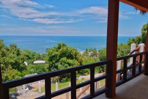 uma vista para o oceano a partir da varanda de uma casa em Colibri Lodge em Ambatoloaka