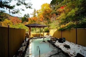 uma piscina com um gazebo num quintal em Yumoto Itaya em Nikko