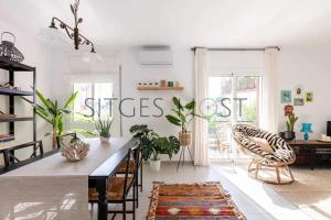 uma sala de estar com uma grande mesa com plantas em Con patio y a 5 minutos de la playa em Sitges