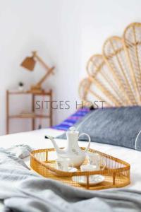 uma bandeja com um conjunto de chá numa cama em Con patio y a 5 minutos de la playa em Sitges