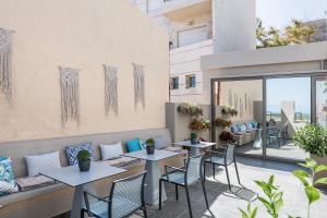 a patio with tables and chairs on a balcony at Ciel Collection Suites in Chania