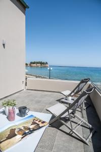einen Stuhl auf einem Balkon mit Meerblick in der Unterkunft Ciel Collection Suites in Chania