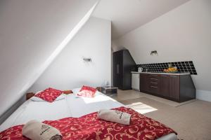 1 dormitorio con 2 camas y almohadas rojas en WILLA SZMARAGD - Śniadania - Zniżki na Termy - Sauna - Bilard - Stoki Narciarskie, en Bukowina Tatrzańska