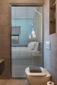 a bathroom with a toilet and a glass shower at Ciel Collection Suites in Chania