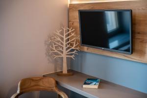 un piccolo albero su una scrivania accanto a una TV di Ciel Collection Suites a Chania