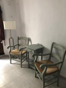 3 Stühle und ein Tisch und eine Lampe in einem Zimmer in der Unterkunft KiCo in Cómpeta
