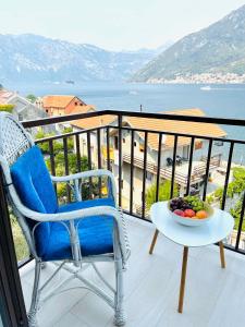 a balcony with a chair and a bowl of fruit on a table at Chic sea front apartment with breathtaking Kotor Bay view in Donji Stoliv