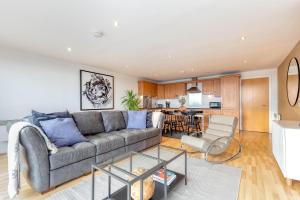 a living room with a couch and a kitchen at Riverview Apartments in Glasgow