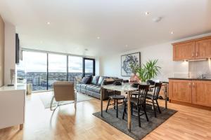 a kitchen and living room with a table and a couch at Riverview Apartments in Glasgow