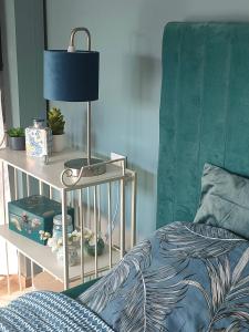 a bedroom with a bed and a table with a lamp at LA MAISON BLEUE, à 20 mn de Strasbourg, sur la route des vins, jusqu'à 6 personnes, Sélestat in Sélestat