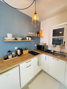 a kitchen with white cabinets and a sink at Chic sea front apartment with breathtaking Kotor Bay view in Donji Stoliv +11 photos