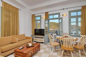 een woonkamer met een bank en een tafel bij Faros Coastal Apartments in Skopelos Town