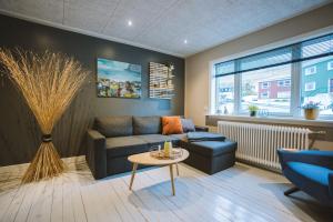 a living room with a couch and a table at Brekkustova - Modern, cosy and spacious apartment in Klaksvík