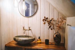 a bathroom with a stone sink and a mirror at Brekkustova - Modern, cosy and spacious apartment in Klaksvík
