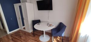 une table blanche et deux chaises bleues dans une pièce dans l'établissement Comfortable Studio Old Town/New City, à Varsovie