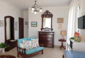 a living room with a blue chair and a television at Il Canneto di Selinunte in Marinella di Selinunte