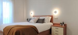 a bedroom with a large bed with white sheets and pillows at Apartament Natura amb Calma in Olot