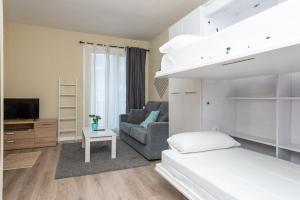 Apartamentos Nevada MIKKA في باس دي لا كاسا: غرفة نوم مع سرير بطابقين وأريكة +37 صورة