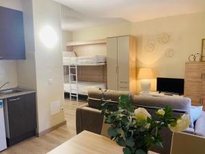 Apartamentos Nevada MIKKA في باس دي لا كاسا: غرفة معيشة مع أريكة وغرفة معيشة مع أسرة بطابقين