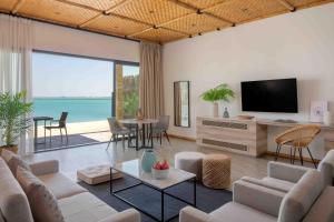 Anantara World Islands Dubai Resort في دبي: غرفة معيشة مع أريكة وتلفزيون