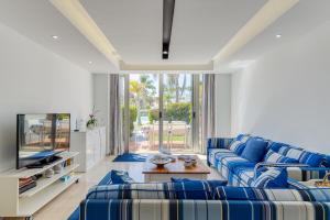 a living room with blue couches and a tv at BLUE MARLIN 14 in Pasito Blanco