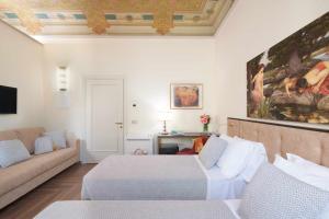 a hotel room with two beds and a couch at Residenza Mondragone in Florence