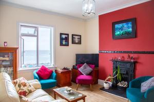 a living room with red walls and a fire place at Seagulls Nest Beachfront Apartment With 3 Bedrooms in Hastings +20 photos