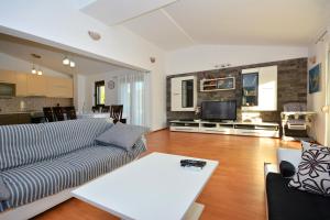 ein Wohnzimmer mit einem Sofa und einem Tisch in der Unterkunft Villa Bisko with heated pool & jacuzzi in Trilj